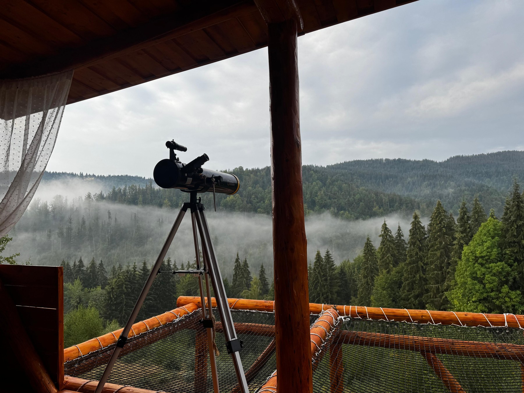 Telescop și plasă suspendată cu vedere spre pădure