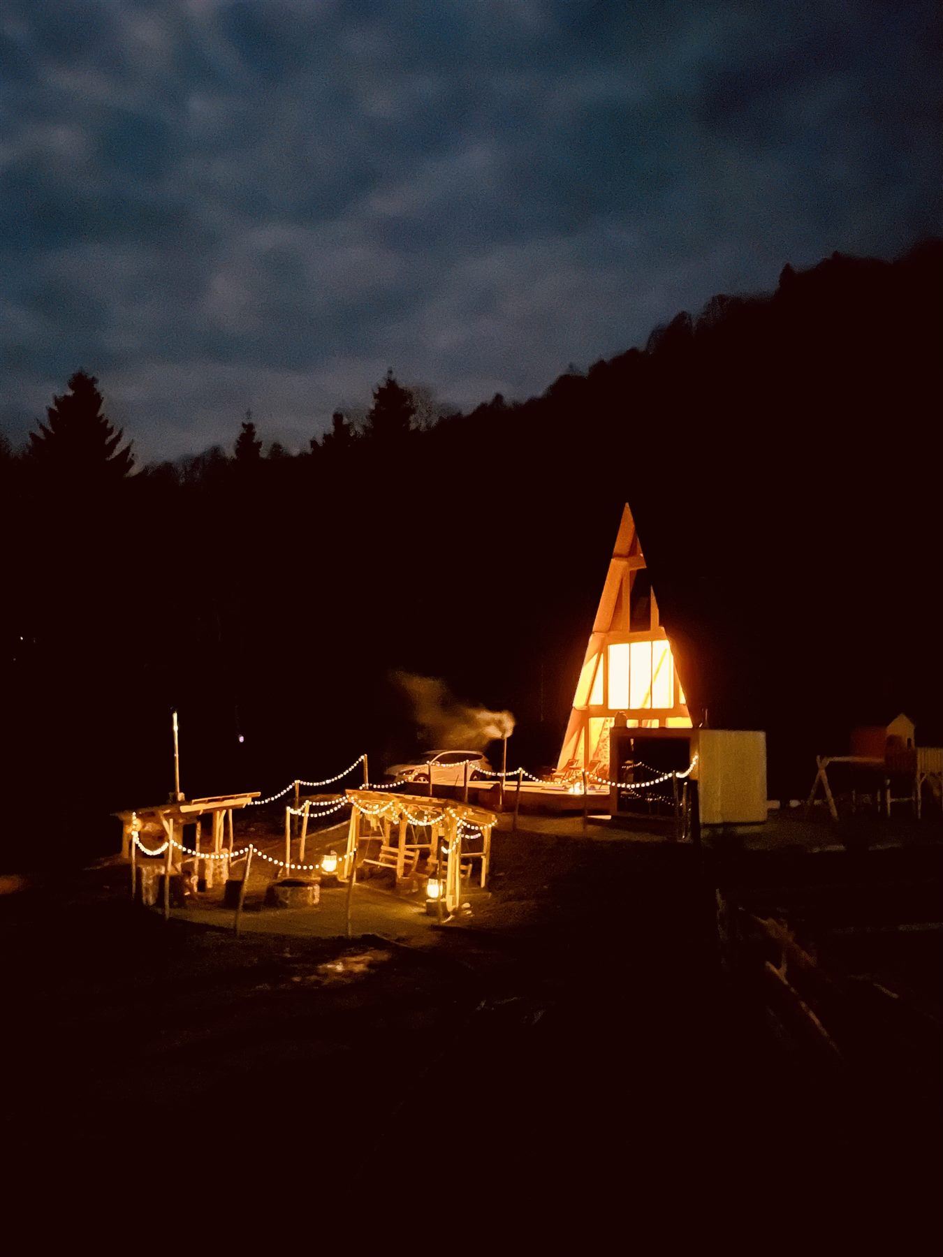 Cabana KayLuna noaptea, cu fatada A-frame luminata in Apuseni